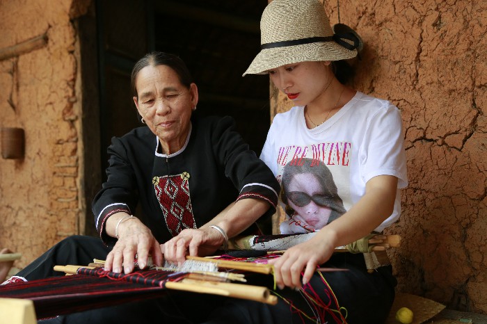 1、游客在和黎族文身阿婆學(xué)織黎錦